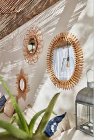 Une Collection De Miroirs En Rotin Habille Le Mur En Beton Cire Blanc De Ce Patio D Inspiration Medi Miroir En Rotin Decoration Salon Blanc Decoration Terrasse