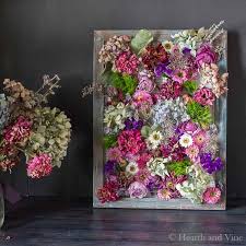 This rectangular piece has a light brown mdf frame, a clear glass panel with pressed yellow flowers inside, and a braided jute rope to hang it with. Wooden Sign Easily Made From Contractor Shims Dried Flowers Diy Flower Canvas Art Flower Wall Art