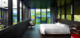 Master bedroom with glass walls. Cottage With Colored Glass Walls And Pre Existing Trees