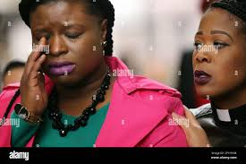 Minneapolis NAACP president Nekima Levy-Pounds wiped tears from her eyes as  Pastor Carmen Means consoled her during a press conference at the Hennepin  County Government Center Wednesday, March 30, 2016 in Minneapolis.