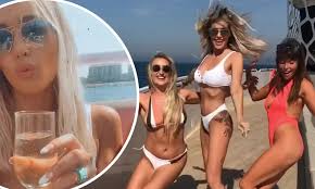 Laura Anderson slips into plunging white bikini as she continues ...
