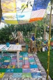 Bunter Sitzplatz Im Garten Der Boden Aus Quadratischen Betonplatten Wurde Mit Hilfe Von Schablo In 2020 Sitzplatz Im Garten Sonnenschutz Garten Bemalte Pflastersteine