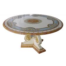 Its round shape and square base are inspired by the elegance of art deco, enriched by a gold leaf accent that details the vertical support to the top. Romice Round Marble Dining Table