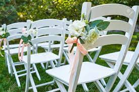 Check spelling or type a new query. White Fresh Flowers With Pink Ribbon On Wedding Chair On Each Side Of Archway Outroods Copy Space Wooden Chairs For Guests On Green Grass In The Garden On Wedding Ceremony Stock Photo