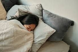 woman sleeping in a bed with a blanket ...