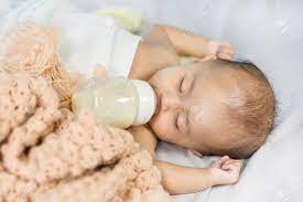 Baby Drinking Milk From Bottle And Sleeping On Bed At Home Stock Photo Picture And Royalty Free Image Image 70759806
