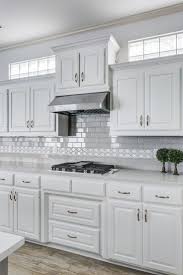 White shaker cabinets with white countertops and white ceramic tile backsplash. Grey Kitchen With White Subway Tiles Novocom Top