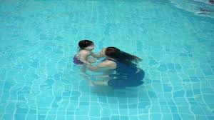 Mom is teaching her daughter to dive in ... | Stock Video | Pond5