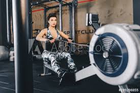 fit woman working out on row machine in