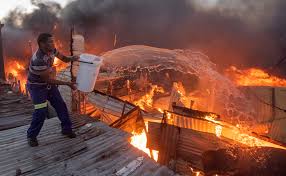 A south african resident of masiphumelele runs past a burning barricade during a protest against the lack of policing in masiphumelele, cape town, south africa on tuesday. No Merry Christmas Two Days After The Devastati