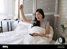 Asian woman raise up her single hands with a satisfied smile to celebrate  the happy ending Stock Photo - Alamy