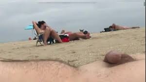 Ein fkk-mann ejakuliert am strand während zwei frauen ihn beobachten