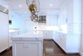 The wood finish is complemented with a lighter, but grainier wood for the flooring, while the white walls and frosted glass hanging cabinets gives this galley kitchen lighter elements. White Cabinets With Marble Looking Quartz Countertop Traditional Kitchen Other By Denise Quade Design Houzz