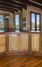 Large kitchen with white walls and rustic cabinetry with tiles flooring. Curved Kitchen Island La Puerta Originals