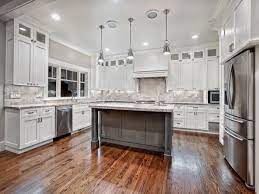 Modern kitchen with white granite countertops and white kitchen cabinets, black tiled backsplash. Fabulous Kitchen Decor Ideas Unique Pendant Light Above White Granite With White Cabinets And White Kitchen Interior White Kitchen Design White Modern Kitchen