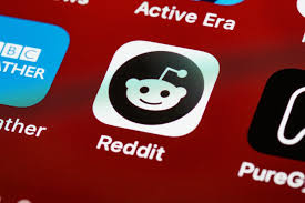 A photo of a Reddit logo on a mobile screen