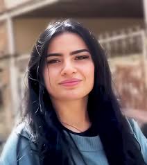 Little girl smiling between rocks in photo