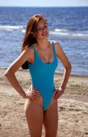 Langhaariges Mädchen in hellblauem Badeanzug am Strand