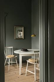 Moody Dark Green Walls And Bare Wooden Floors Simple White Scandinavian Style Kitchen Table And Chairs Eclectic Interior Design Dining Room Decor Interior