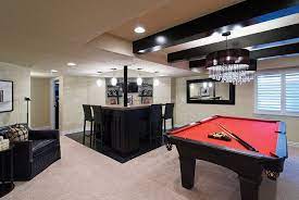 An open floorplan creatively incorporates space for a bar and seating, pool area, gas fireplace, and theatre room (set off by seating and cabinetry). Chadsworth Point Basement Finished Basement Company Small Pool Table Pool Table Room Entertainment Room