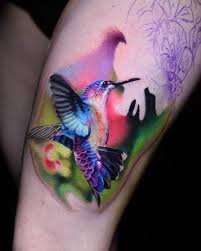 A Bright Colorful Hummingbird On Girls Thigh Part Of A Larger Piece Tattoos Colorful Hummingbird Tattoo Hummingbird Tattoo Watercolor