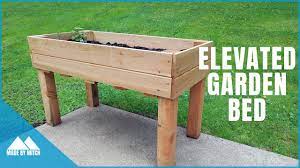 To build a wooden planter box, start by cutting some wooden planks so you have 2 that are 2 feet long and 2 that are 4 feet long. Diy Elevated Garden Bed Youtube