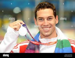 England's Simon Burnett with his silver medal after the Men's 100m  Freestyle during Day Four of the 2010 Commonwealth Games at the Dr SPM  Aquatics Centre in New Delhi, India Stock Photo -