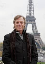 Caucasian man standing in front of Eiffel Tower, Paris, Ile de France,  France - Royalty-free Stock Photo | Dissolve