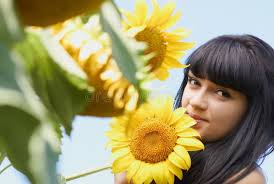 Girl with Sunflower Under Blue Sky Stock Image