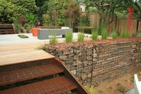 Here Stone Filled Gabions Have Been Used To Create An Interesting And Cost Effective Retaining Wall Backyard Garden Design Sloped Garden Backyard Garden Layout