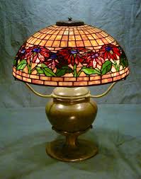 Tiffany studios patinated bronze table lamp with a leaded glass poinsettia shade, the shade signed and numbered 556, the base signed and numbered 534, 22'' h., 14'' dia. Century Studios 2019