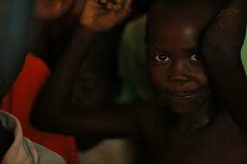 Boy wearing white tank top sitting down near girl in pink star-print tank  top photo