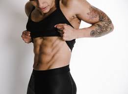 Female bodybuilder with perfect biceps strong woman with tied up black hair and shorts curling dumbbell over gray background with copy space. Woman Flexing Back Muscles On Bench Royalty Free Stock Image Storyblocks