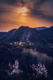 上花楼西望 延庆长城上花楼虽残破但古朴真实 墙基远远望去像是一条长长的碎石路 春天里山坡上开满了山桃花 在夕阳的照射下非常亮眼 although the hualou on the great wall is broken it is scenic beauty scenic natural landmarks