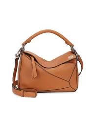 Crafted in soft natural and soft grained calfskin in large and xl sizes, and in colours including black, tan and seasonal animations. Loewe Puzzle Small Multi Function Leather Bag In Tan Modesens
