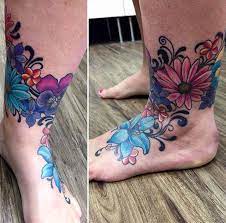 Flower Tattoo On Foot And Ankle Colourful Flower Realism Daisies Pansies Plumeria And Lily And Swirls Flower Tattoo Flower Tattoo On Foot Daisy Tattoo