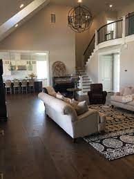 Contemporary Living Room Modern High Ceilings With A Beautiful Staircase Dark Hardwood Brown Living Room Decor Brown Living Room Living Room Hardwood Floors