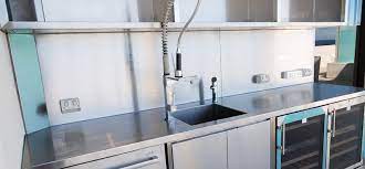 This outdoor kitchen comes with a stainless steel grill, small stove top area, open lower shelving, and an island seating area. Stainless Kitchens Stainless Benches Stainless Cabinets Southern Stainless