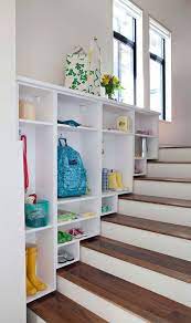 Beautifully designed mudroom and craft room combo features two white drum capiz pendants hung in front of windows dressed yellow and blue ikat pleated valances flanking a cork board framed with. Before After Over The Stairs Mudroom California Closets Apartment Therapy Home California Closets Entryway Storage