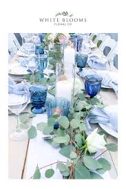 Blue Wedding Reception With Eucalyptus Candles And Blush Pink And White Floral Arrangeme In 2020 White Floral Arrangements Blue Wedding Receptions Floral Arch Wedding