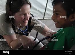 U.S. Air Force Capt. Katie Coble, with the 96th Medical Support Group from  Eglin Air Force Base, Florida, checks a patient's heart beat at a medical  readiness event in Dangriga, Belize, May