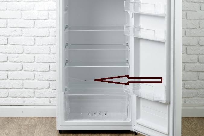The internal defrost drain hole on the rear cabinet wall, AI generated