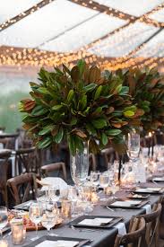 Tall Magnolia Leaf Centerpieces Atop Cool Gray Linens In 2020 Magnolia Leaves Centerpiece Wedding Table Centerpieces Wedding Floral Centerpieces