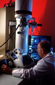 LT. COL. (Dr.) Gerald Merritt looks into an electron microscope at the new  David Grand Medical Center