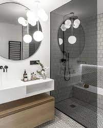 The flooring is a beautiful black and white pattern with half the wall covered in a dark grey pvc material with long rectangular stripes in contrast to the white. A T E L I E R D A A A Na Instagramie Wattignies Visite Privee A Paris Round Mirror Bathroom Black Shower Modern Small Bathrooms