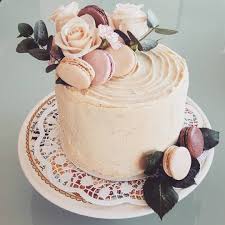 White Simple Wedding Cake With White Chocolate Ganache Macarons And Flowers Whimsical Wedding Cakes Macaron Cake Chocolate Cake Decoration