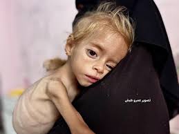 A mother and her children gather lentils from the ground, spilled from aid  trucks in Gaza, in a manifestation of the ongoing hunger crisis in Gaza,  resulting from Israel's ongoing blockade on