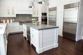Combining it with dark wenge kitchen cabinets, medium stained wood flooring and white counter tops, a layering of contrasting colors and textures are formed. White Kitchen With A Concrete Island And Dark Wood Floors Haus