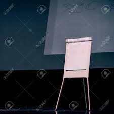 podium of the seminar with a flip chart and a large screen