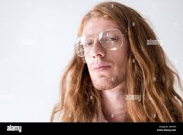 portrait of handsome man with curly ginger hair and glasses looking at  camera isolated